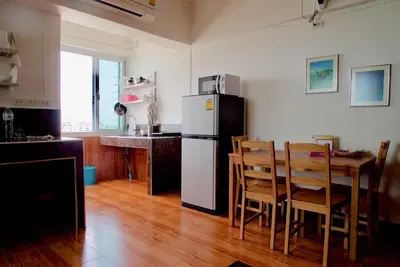 a kitchen with a refrigerator and a table with chairs at SKB Mansion close to MRT in Hua mark in Bangkok