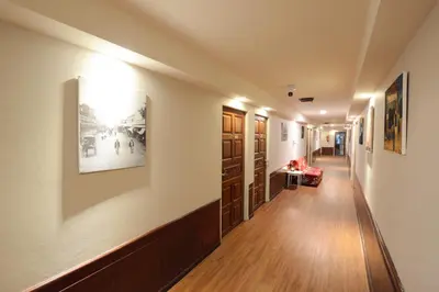 a hallway in a building with paintings on the walls at Thaiphiphat house in Bangkok