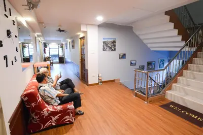 two people sitting on a couch in a living room at Thaiphiphat house in Bangkok