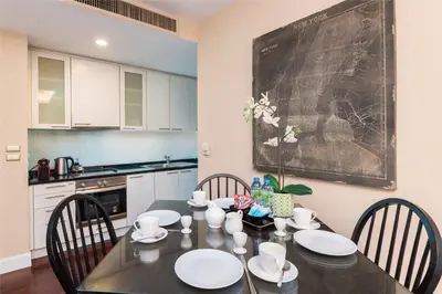 a kitchen with a table with chairs and a chalkboard on the wall at Sky Villas Apartments in Bangkok