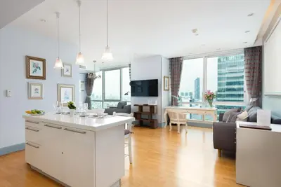 a kitchen and living room with a view of the city at Sky Villas Apartments in Bangkok
