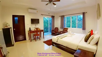 a bedroom with a bed and a desk in it at Baan Glangsuan Bang Kobua in Bang Chak