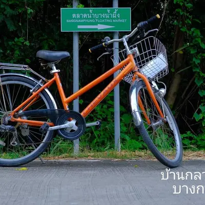 an orange bike parked next to a street sign at Baan Glangsuan Bang Kobua in Bang Chak