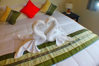 two towel swans sitting on top of a bed at Baan Glangsuan Bang Kobua in Bang Chak