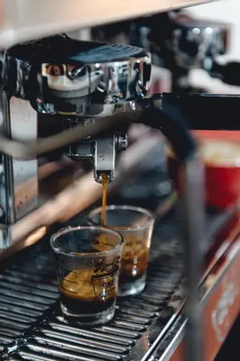 a coffee machine pouring coffee into two cups at Tales Khaosan (Cafe & Hostel) in Bangkok