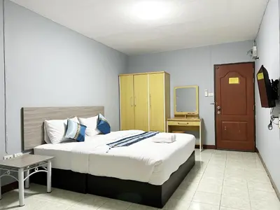a bedroom with a large bed and a television at Goody Hotel in Bangkok