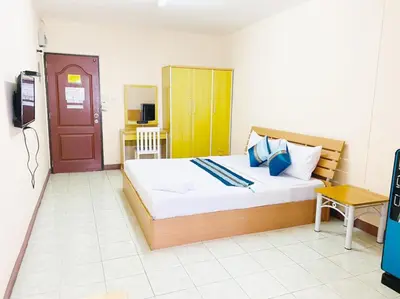 a bedroom with a large bed and a television at Goody Hotel in Bangkok