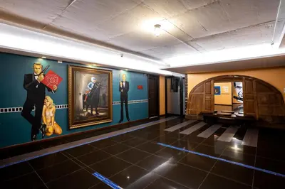 a room with paintings on the wall and a painting of a man at MeStyle Place Hotel in Bangkok