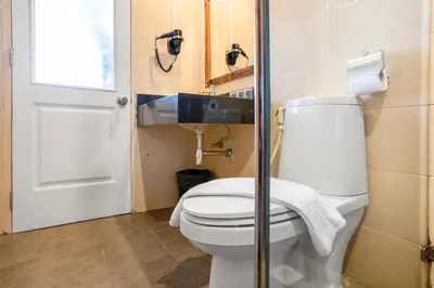 a bathroom with a toilet with a glass door at MeStyle Place Hotel in Bangkok