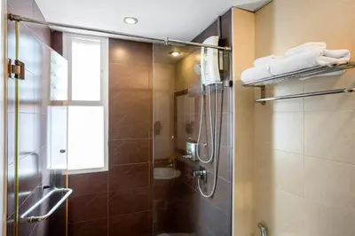 a shower with a glass door in a bathroom at MeStyle Place Hotel in Bangkok