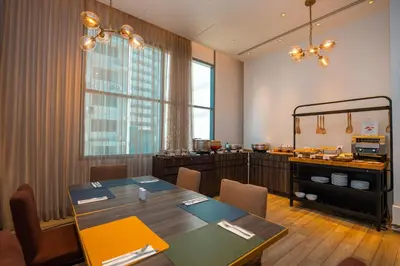 a restaurant with a table and chairs in a room at Hyatt Place Bangkok Sukhumvit 24 in Bangkok