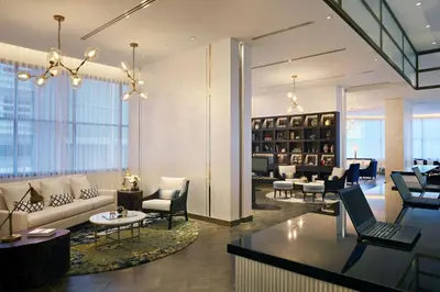 a lobby with a couch and chairs and tables at Hyatt Place Bangkok Sukhumvit 24 in Bangkok