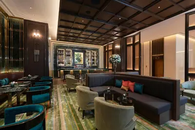 a hotel lobby with a couch and tables and chairs at The Landmark Bangkok in Bangkok