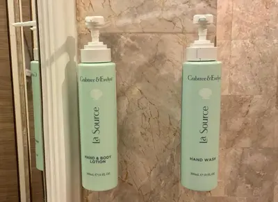 two bottles of soap sitting on a wall at Jubilee Prestige Hotel Ratchadapisek in Bangkok
