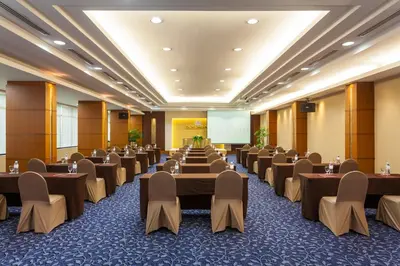a conference room with tables and chairs and a screen at Twin Towers Hotel in Bangkok