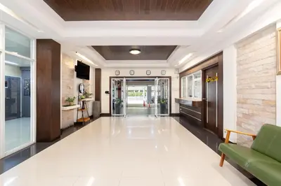 an office lobby with a green couch and a hallway at P-Park Suvarnabhumi in Bangkok