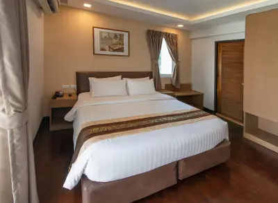 a bedroom with a large bed with white sheets at Stable Lodge - SHA Certified in Bangkok