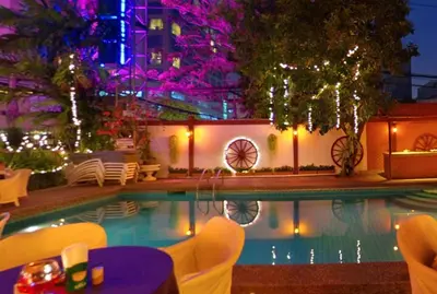 a pool with chairs and a table and a building at Stable Lodge - SHA Certified in Bangkok