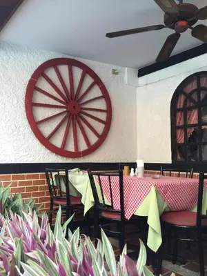 a table with chairs and a red target on a wall at Stable Lodge - SHA Certified in Bangkok