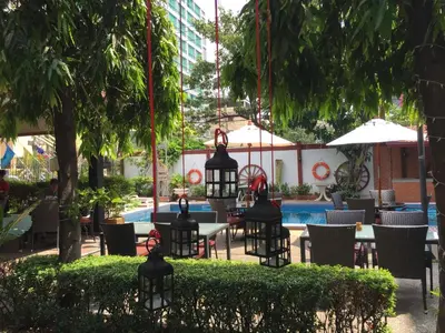 a restaurant with tables and chairs next to a pool at Stable Lodge - SHA Certified in Bangkok