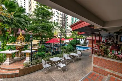 an outdoor patio with tables and chairs and a pool at Stable Lodge - SHA Certified in Bangkok
