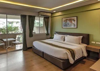 a bedroom with a large bed and a balcony at Stable Lodge - SHA Certified in Bangkok