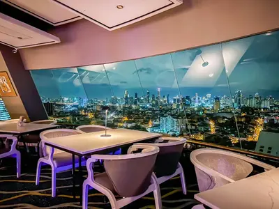a restaurant with tables and chairs and a view of the city at Grand China Bangkok in Bangkok