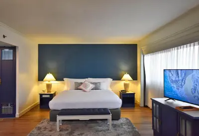 a bedroom with a large bed and a flat screen tv at Grand China Bangkok in Bangkok