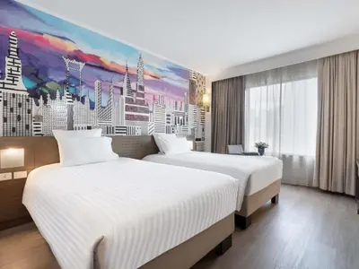 two beds in a hotel room with a painting at Novotel Bangkok on Siam Square in Bangkok
