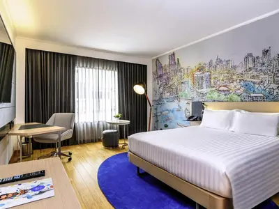 a hotel room with a bed and a desk at Novotel Bangkok on Siam Square in Bangkok