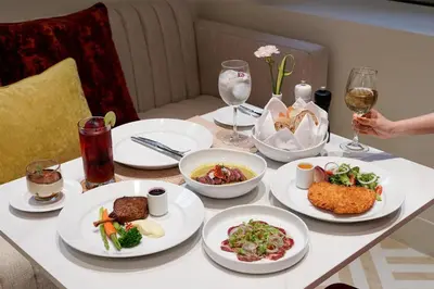 a table with white plates of food on it at Radisson Hotel Chateau de Bangkok in Bangkok