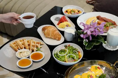 a table topped with plates of food and drinks at Radisson Hotel Chateau de Bangkok in Bangkok