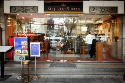 a store window with a reflection of a man in it at Majestic Suites Hotel in Bangkok