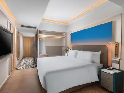 a bedroom with a large white bed and a flat screen tv at Pipa Hotel Bangkok Sukhumvit 11 in Bangkok