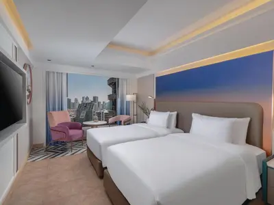 a hotel room with two beds and a television at Pipa Hotel Bangkok Sukhumvit 11 in Bangkok