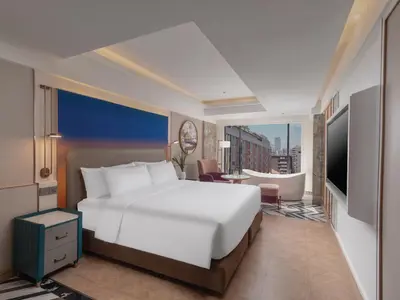 a bedroom with a large bed and a living room at Pipa Hotel Bangkok Sukhumvit 11 in Bangkok
