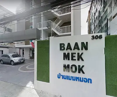 a sign for a bank next to a building at Baan mek mok in Bangkok