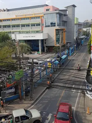 a city street with cars parked in front of a building at Baan mek mok in Bangkok