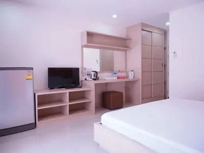 a bedroom with a bed and a desk with a television at Baan mek mok in Bangkok