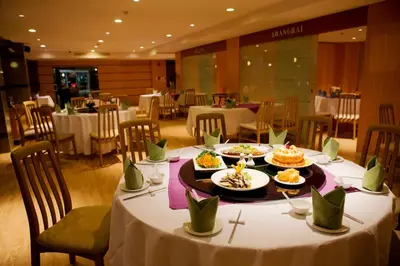 a table with plates of food on it in a restaurant at Trang Hotel Bangkok - SHA Plus in Bangkok