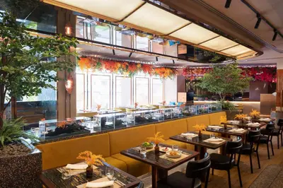 a restaurant with tables and chairs and a bar at Valia Hotel Bangkok in Bangkok
