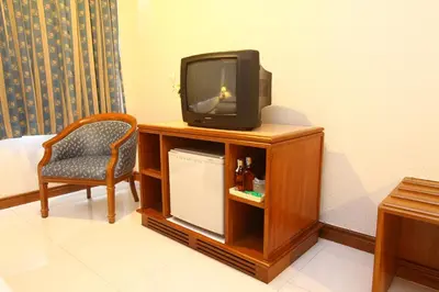 a tv sitting on top of a cabinet with a chair at Silom Avenue Inn in Bangkok