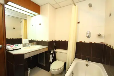 a bathroom with a toilet and a sink and a tub at Silom Avenue Inn in Bangkok