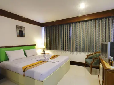 a hotel room with a bed and a television at Silom Avenue Inn in Bangkok