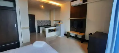 a small room with a bed and a tv in it at @Home Residence in Bangkok