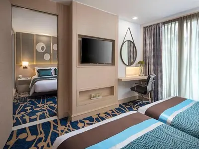 a hotel room with a bed and a television at Solitaire Bangkok Sukhumvit 11 in Bangkok