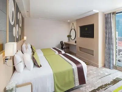 a hotel room with a bed and a television at Solitaire Bangkok Sukhumvit 11 in Bangkok