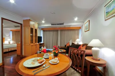a living room with a table and a couch at Admiral Suites Bangkok in Bangkok