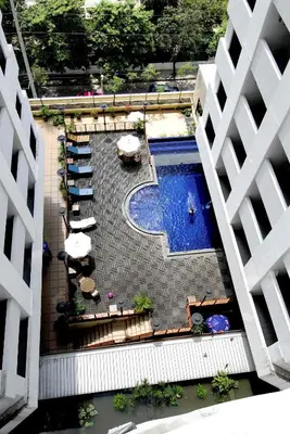 an overhead view of a swimming pool with tables and umbrellas at Princeton Bangkok in Bangkok