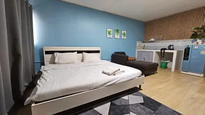 a bedroom with a bed and a blue wall at อิมแพ็ค เมืองทองธานี ห้องเช่ารายวัน เมืองทอง popular condo C5 in Ban Bang Phang